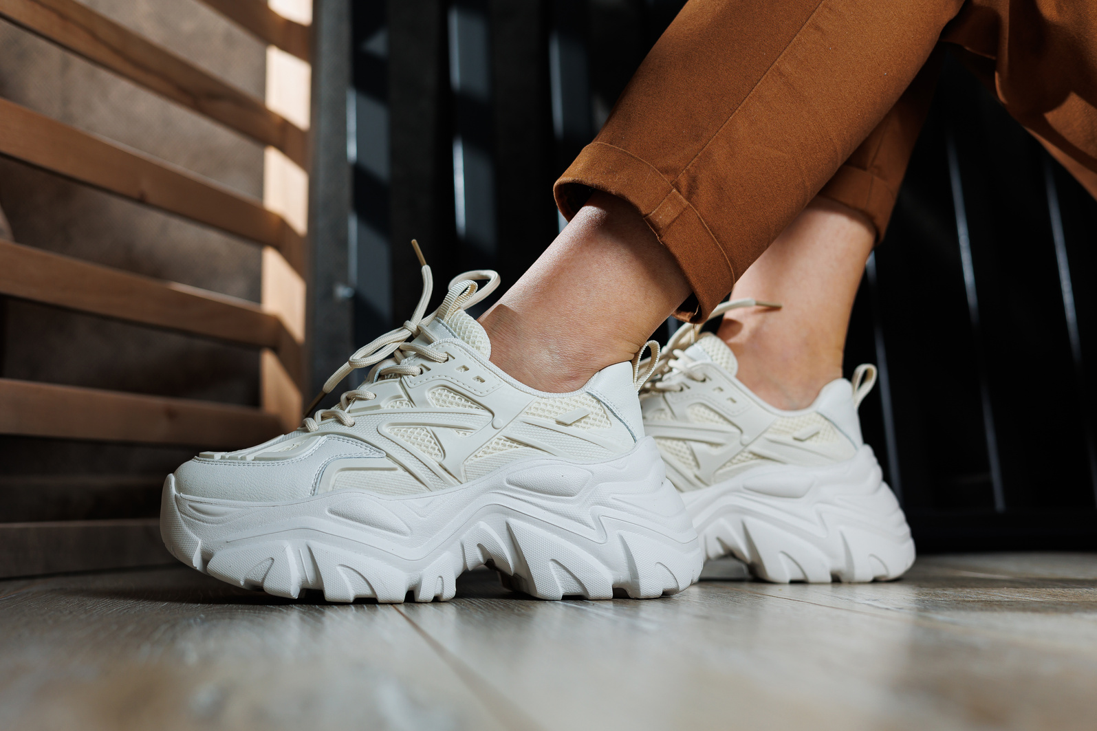 Collection of summer leather sneakers for women. Close-up of female legs in white sneakers. Women's summer sneakers with laces.